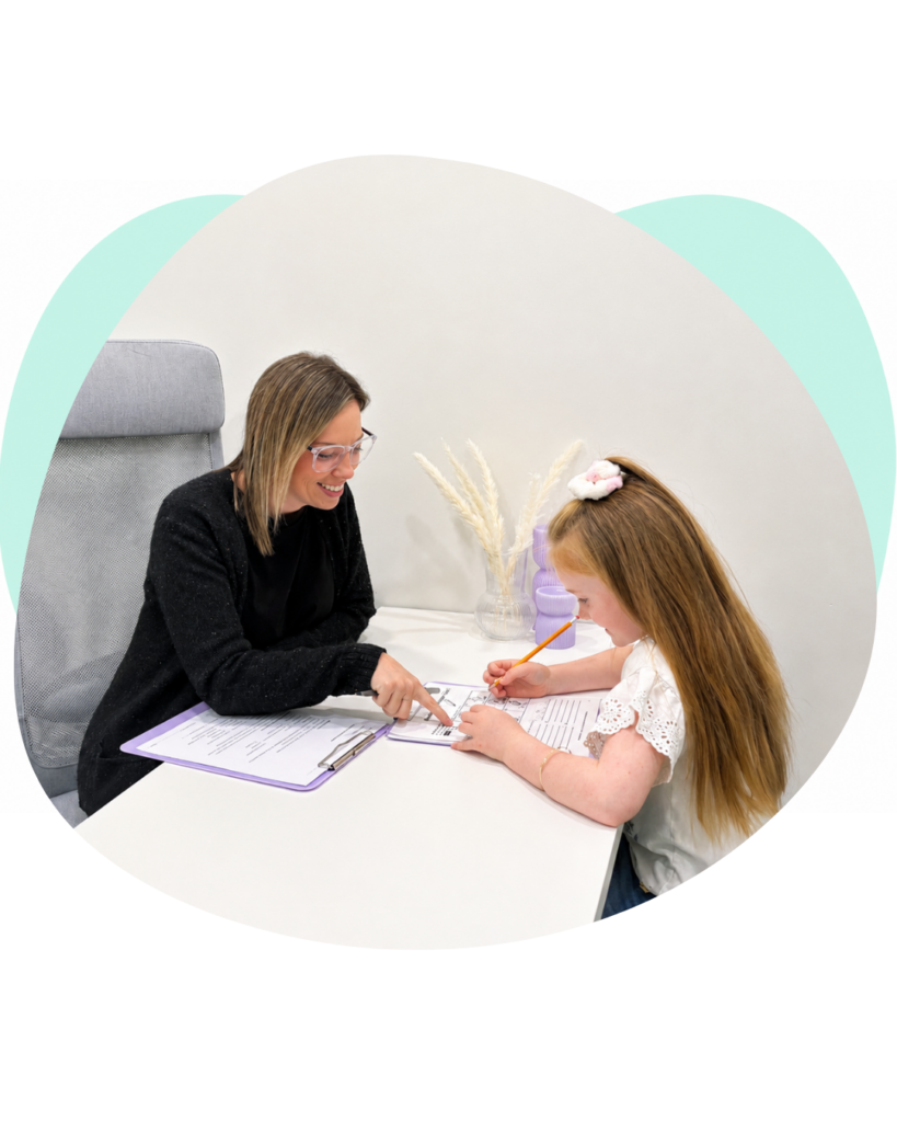 Psychologist and a child working on an assessment activity at a table